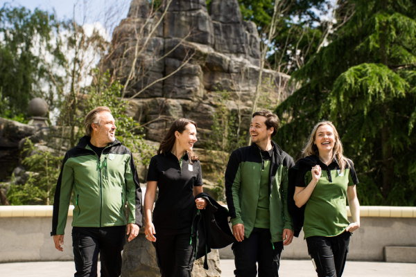 Vier personen met bedrijfskleding van Diergaarde Blijdorp aan het werk in de dierentuin in full custom made-bedrijfskleding ontworpen door Outfit company wear