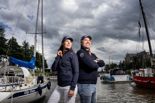 Damen 600×400 Twee personen in full custom made-kleding van Damen Shipyards tussen de boten in de haven