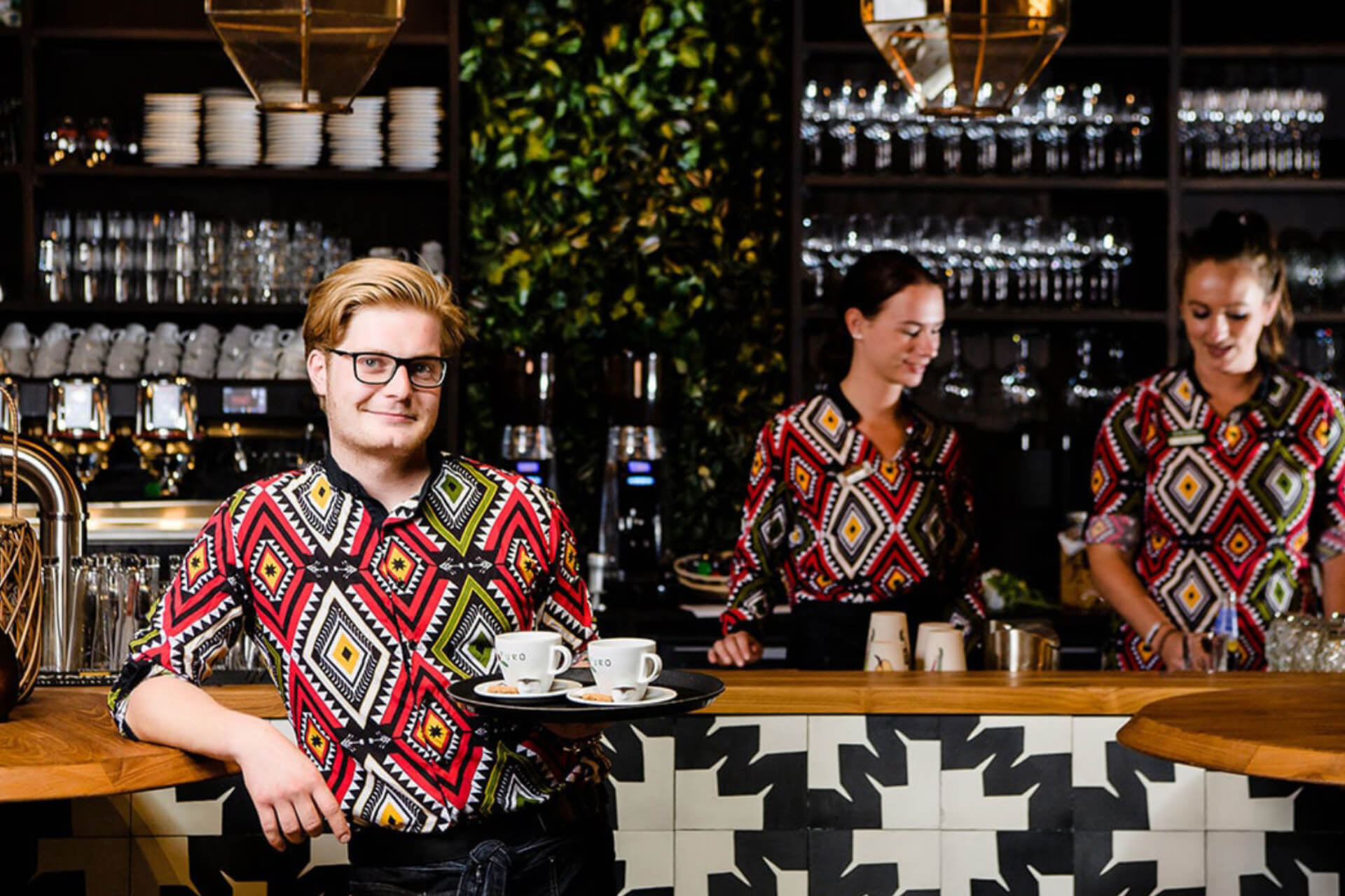 Medewerkers van Beekse Bergen aan het werk in de horeca van het safaripark gekleed in full custom made-bedrijfskleding met unieke Afrikaanse print door Outfit company wear