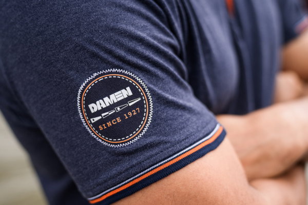 Badge borduring op full custom made-polo van Damen Shipyards ontworpen en gemaakt door Outfit company wear
