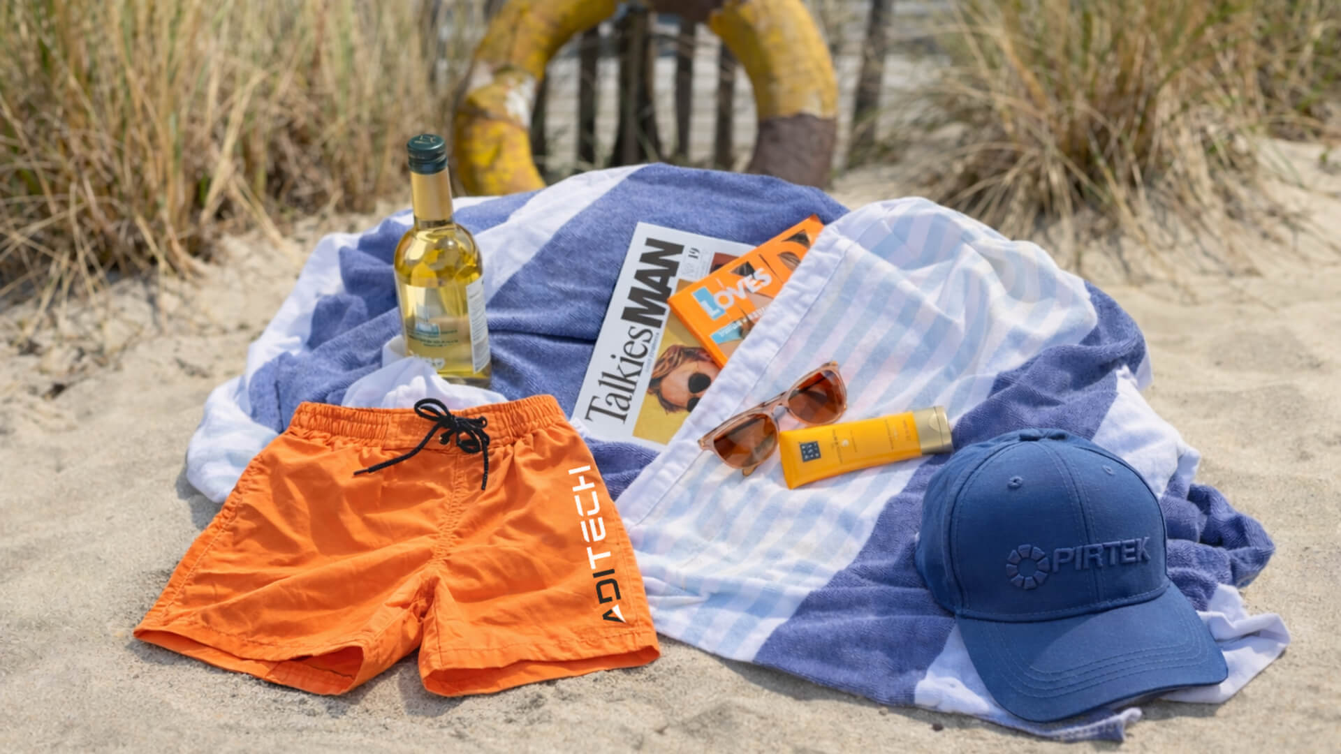 Zomercadeau header Zomers pakket met een gepersonaliseerde handdoek, zwembroek en cap. Aangevuld met een fles wijn en magazines
