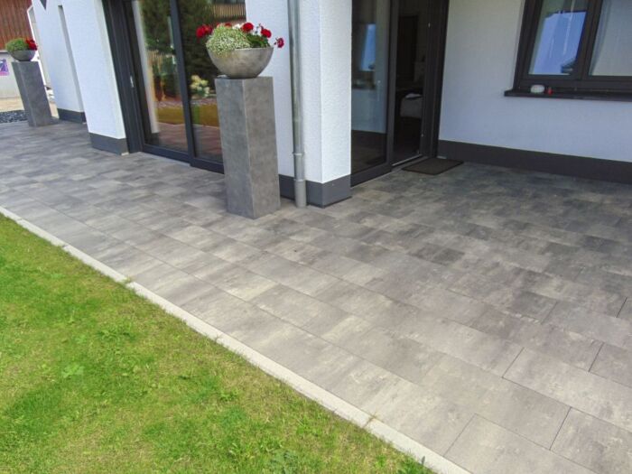 Terras rondom huis met grjize tegel